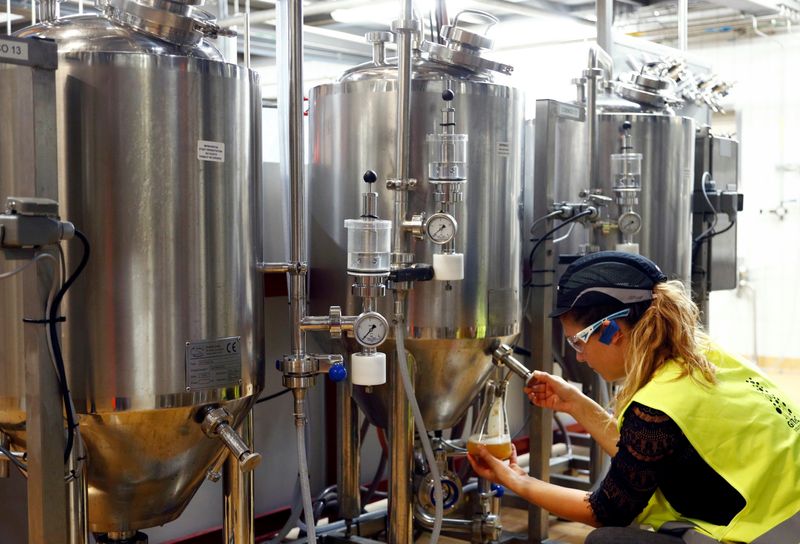 A worker checks beer quality at Anheuser-Busch InBev brewery in Leuven, Belgium November 25, 2019. REUTERS/Francois Lenoir/File Photo