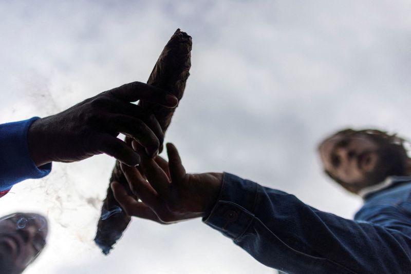 FILE PHOTO: A man passes a marijuana joint during the 420 Hippie Hill festival at Golden Gate Park in San Francisco, California U.S., April 20, 2022. REUTERS/Carlos Barria/File Photo