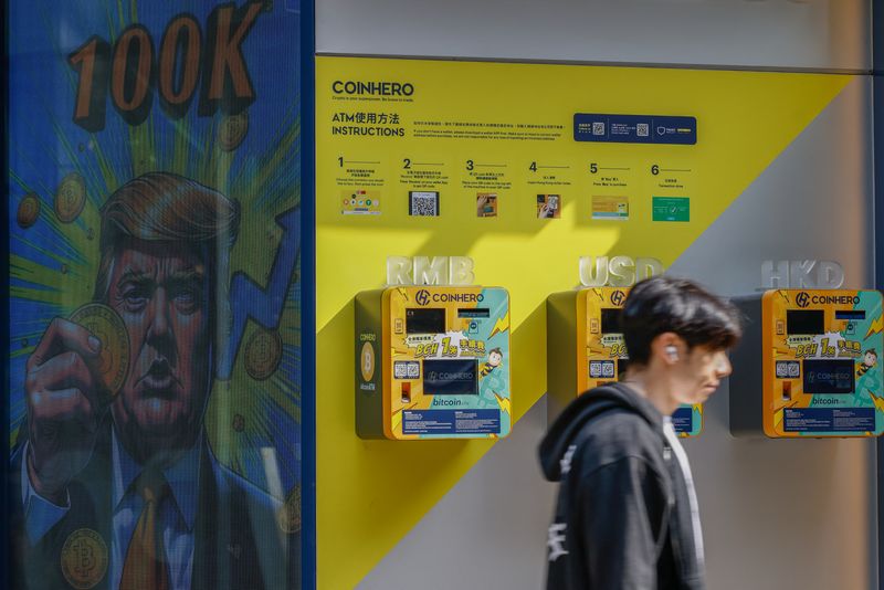 An illustration featuring U.S. President-elect Donald Trump holding Bitcoin is displayed outside a cryptocurrency exchange store after Bitcoin soars above $100,000, in Hong Kong, China, December 5, 2024. REUTERS/Tyrone Siu