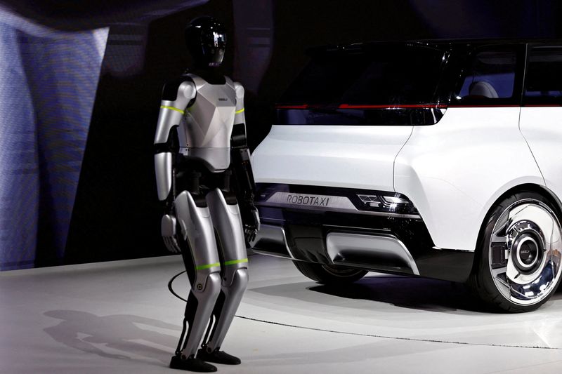 A humanoid robot stands next to Geely's Robotaxi prototype, Eva Cab, unveiled at the Beijing International Automotive Exhibition (Auto China), in Beijing, China April 24, 2026. REUTERS/Tingshu Wang
