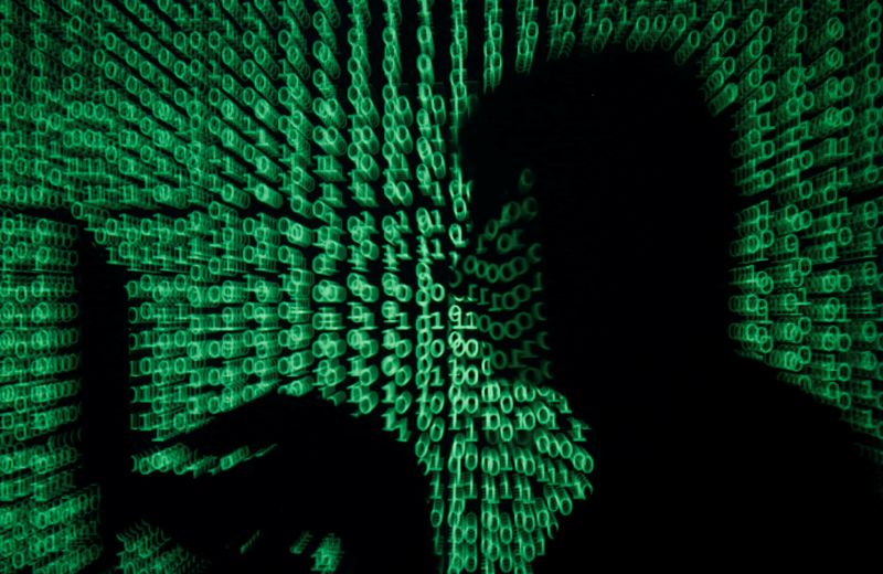 A man holds a laptop computer as cyber code is projected on him in this illustration picture taken on May 13, 2017. Capitalizing on spying tools believed to have been developed by the U.S. National Security Agency, hackers staged a cyber assault with a self-spreading malware that has infected tens of thousands of computers in nearly 100 countries. REUTERS/Kacper Pempel/Illustration/File Photo