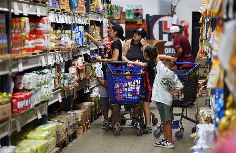 FILE PHOTO: Shoppers check prices at a supermarket in Villa Martelli on the outskirts of Buenos Aires, Argentina January 13, 2026. REUTERS/Agustin Marcarian/ File Photo