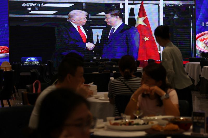 A screen shows news footage of the bilateral meeting between Chinese President Xi Jinping and U.S. President Donald Trump on the sidelines of the Asia-Pacific Economic Cooperation (APEC) summit in South Korea's Busan, at a restaurant in Shenzhen, Guangdong province, China October 30, 2025. REUTERS/Tingshu Wang