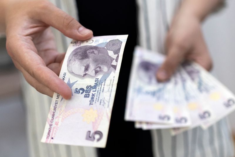 Woman holds Turkish Lira banknotes in this illustration taken May 30, 2022. REUTERS/Dado Ruvic/Illustration