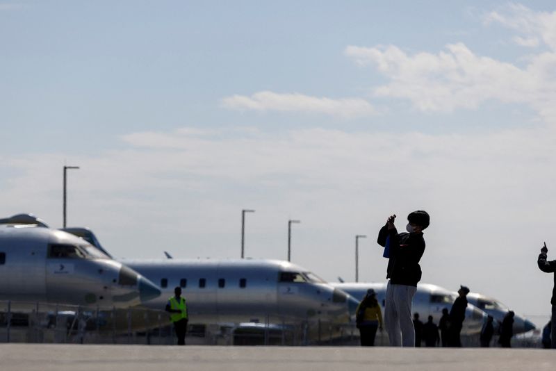Bombardier employees and their guests take photos and look at parked planes outside the factory as Canadian business jet maker Bombardier holds an investor day at their plant in Mississauga, Ontario, Canada May 1, 2024.  REUTERS/Carlos Osorio