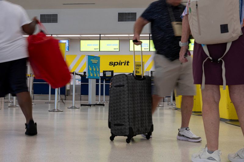 Passengers walk past the Spirit Airlines check-in area at Luis Munoz Marin International Airport after the airline announced it was ceasing operations early Saturday following an impasse in talks with some creditors over a $500 million government bailout plan, in Carolina, Puerto Rico, May 2, 2026. REUTERS/Ricardo Arduengo