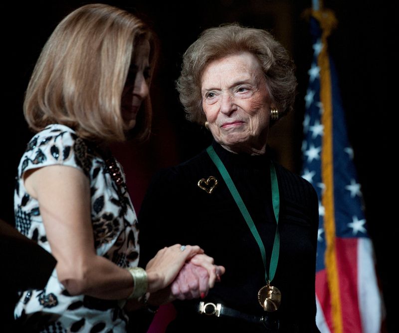 FILE PHOTO: California first lady Anne Gust Brown (L) walks on the stage with Gap clothing store chain founder Doris Fisher after she was inducted along with her late husband Donald, during the 2011 California Hall of Fame Induction Ceremony in Sacramento, California December 8, 2011. REUTERS/Hector Amezcua/Pool/File Photo