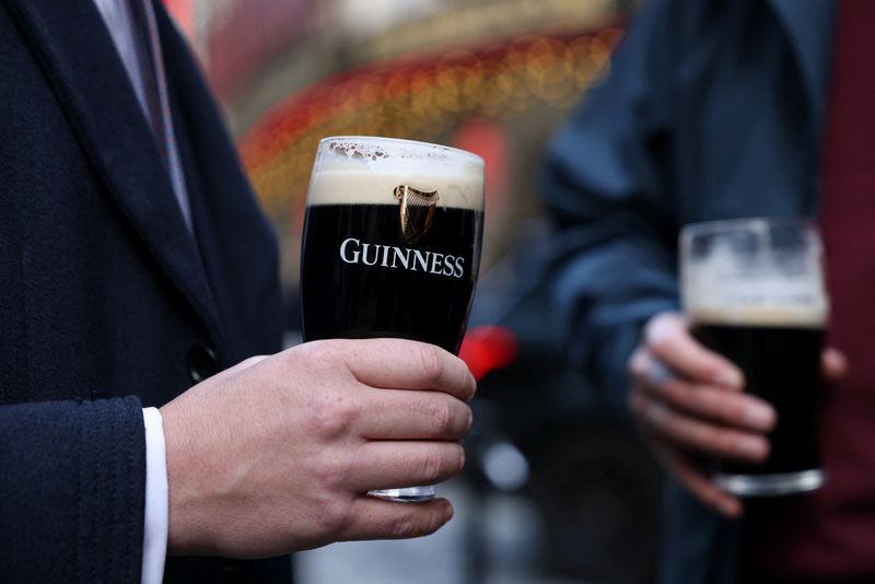 People drink Guinness beers The Devonshire pub in Soho, London, Britain, October 10, 2024. REUTERS/Hollie Adams