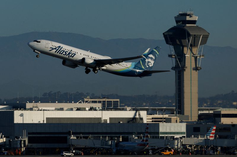 FILE PHOTO: An Alaska Airlines commercial airliner takes-off from Los Angeles International Airport in Los Angeles, California, U.S., November 6, 2025. REUTERS/Mike Blake/File Photo