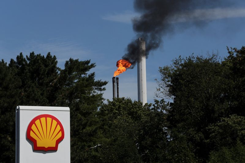 FILE PHOTO: The sign of a Shell petrol station is seen in front of a burning pilot flame atop a flare stack at the refinery of the Shell Energy and Chemicals Park Rheinland in Godorf near Cologne, Germany, August 3, 2022.  REUTERS/Wolfgang Rattay/File Photo