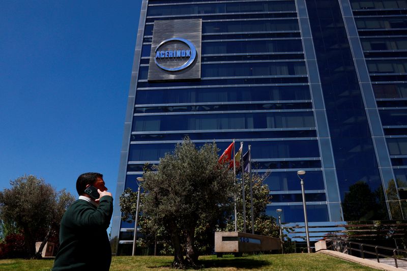 A man uses his phone as the logo of Spanish stainless steel manufacturer Acerinox is displayed on their offices in Madrid, Spain, April 22, 2024. REUTERS/Susana Vera