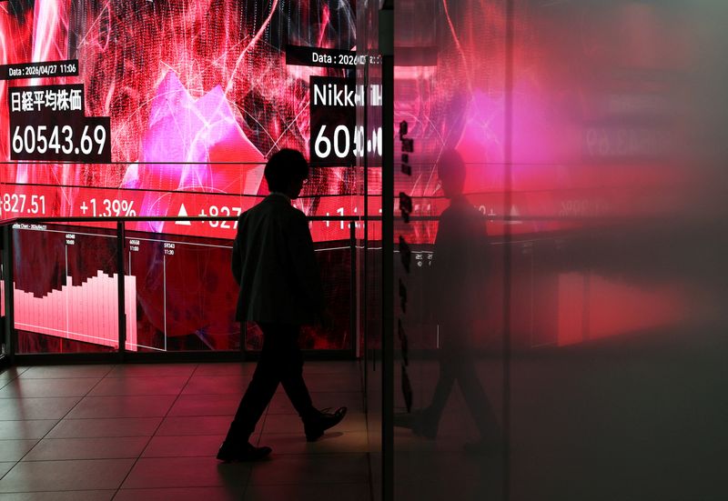 A man walks in front of an electronic screen displaying Japan's Nikkei share average inside a conference hall in Tokyo, Japan, April 27, 2026. REUTERS/Issei Kato