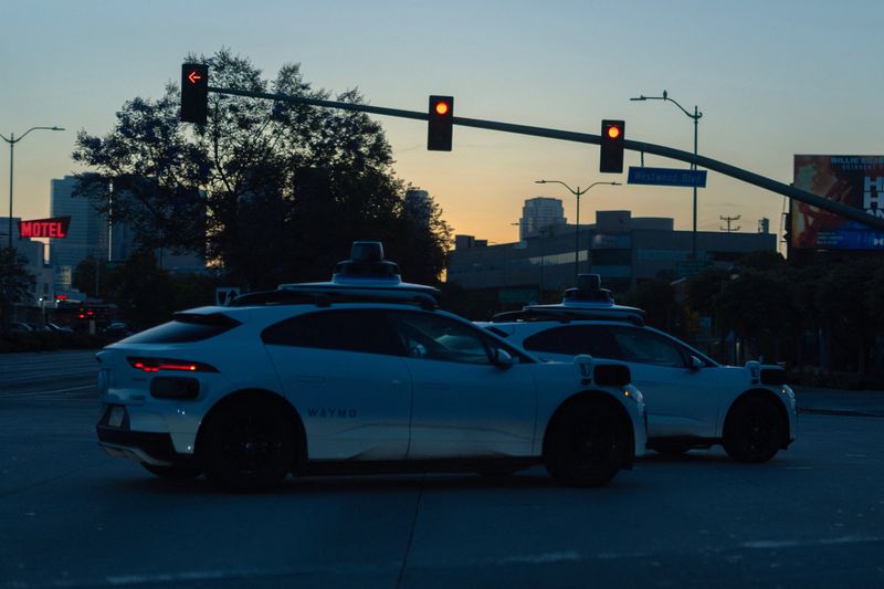 Two Waymo driverless taxis in the early morning on the streets of Santa Monica, California, U.S., May, 6, 2026.  REUTERS/Mike Blake