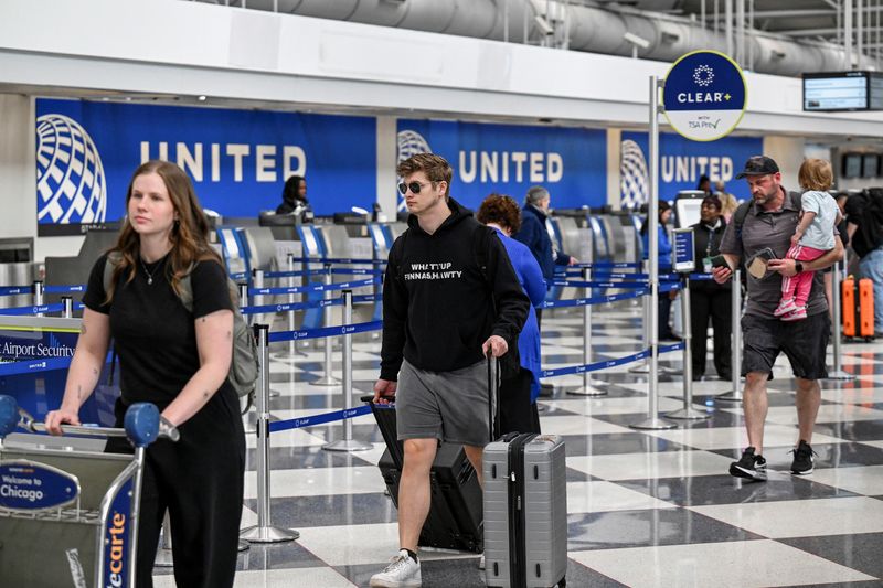 Passengers walk through the United Airlines terminal at Chicago O'Hare International Airport in Chicago, Illinois, U.S., April 14, 2026. REUTERS/Joshua Lott