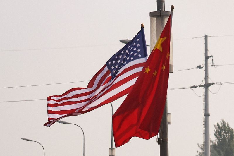 National flags of China and the United States flutter on a road, ahead of the U.S. President Donald Trump's state visit to China, in Beijing, China, May 13, 2026. REUTERS/Tingshu Wang