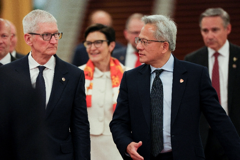 Nvidia CEO Jensen Huang and Apple CEO Tim Cook arrive for the meeting between Chinese Premier Li Qiang and U.S. business representatives, at the Great Hall of the People in Beijing, China May 14, 2026. REUTERS/Go Nakamura/Pool