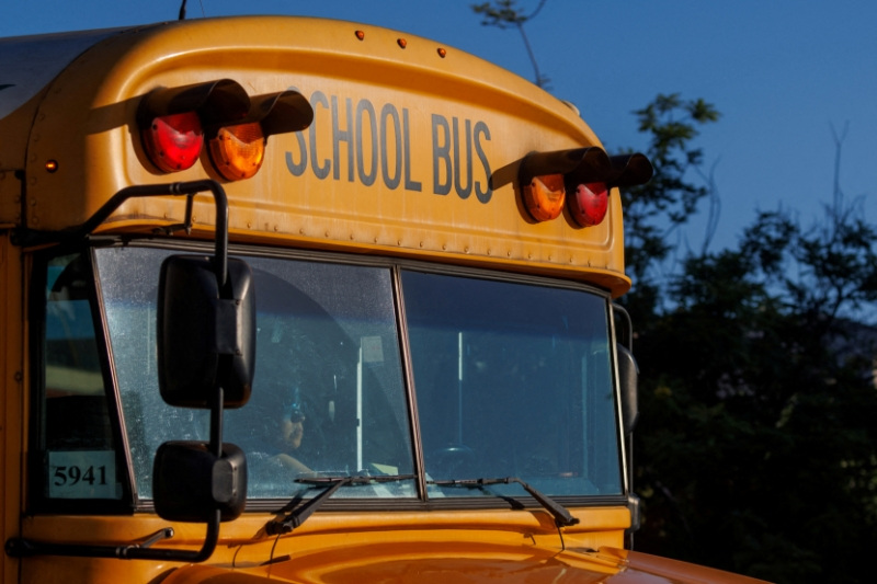 FILE PHOTO: File Photo: A school bus driver navigates while driving through downtown Los Angeles, California, U.S. July 19, 2023.  REUTERS/Mike Blake/File Photo