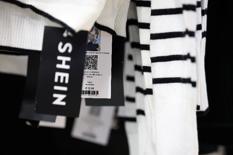 A Shein logo is seen on a tag near a price of a sweater for sale in the first physical space of Chinese online fast-fashion retailer Shein on opening day  inside the Le BHV Marais department store, the Bazar de l'Hotel de Ville, in Paris, France, November 5, 2025. REUTERS/Sarah Meyssonnier