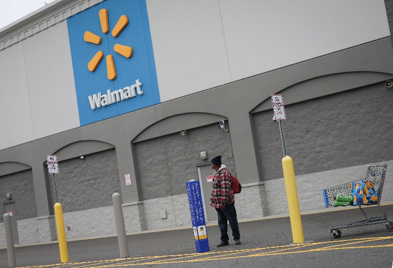 A customer waits for a ride outside a Walmart Supercenter retail store in North Bergen, New Jersey, U.S., November 21, 2025.  REUTERS/Mike Segar