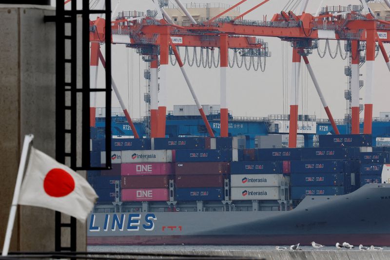 FILE PHOTO: A Japanese national flag flutters in front of cargo containers at an industrial port in Tokyo, Japan, February 16, 2026. REUTERS/Kim Kyung-Hoon/File Photo
