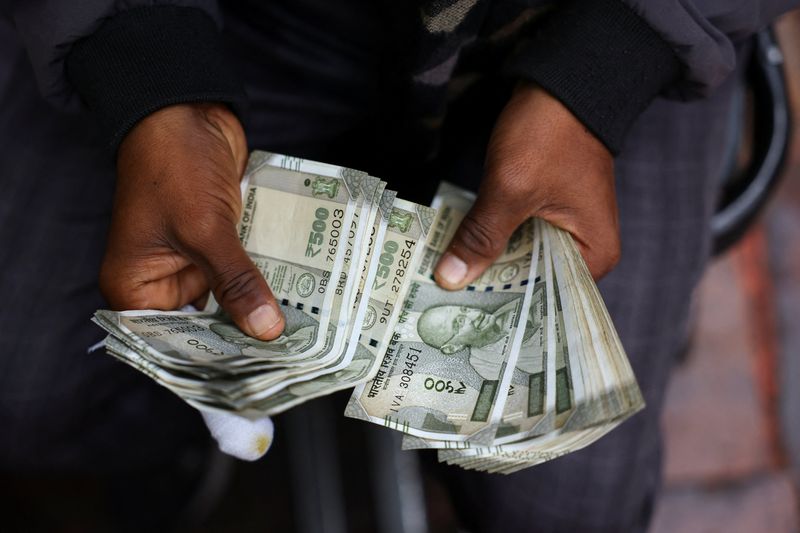 A man counts Indian currency notes at a roadside currency exchange stall in the old quarters of Delhi, India, February 2, 2026. REUTERS/Anushree Fadnavis