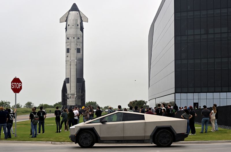 SpaceX employees watch the Starship spacecraft rolling past the production facility toward launch pad 2 ahead of its 12th test flight, in Starbase, Texas, U.S., May 19, 2026. REUTERS/Steve Nesius