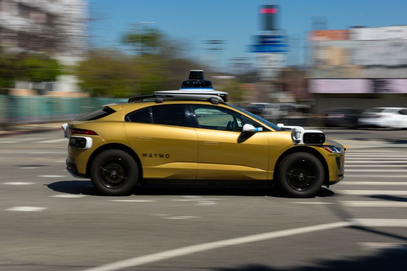 A golden painted Waymo driverless vehicle drives down a street in Los Angeles, California, U.S., March 18, 2026.   REUTERS/ Mike Blake