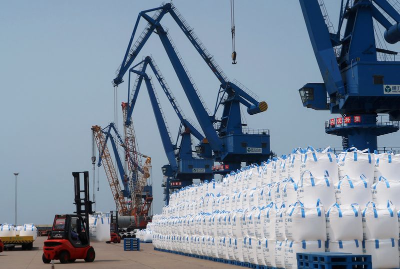 FILE PHOTO: A worker drives a forklift past sacks of polyester-making chemicals, waiting to be shipped, at Hengli Petrochemical's new refining, petrochemical complex at Changxing island in Dalian, Liaoning province, China July 16, 2018.REUTERS/Chen Aizhu/File Photo