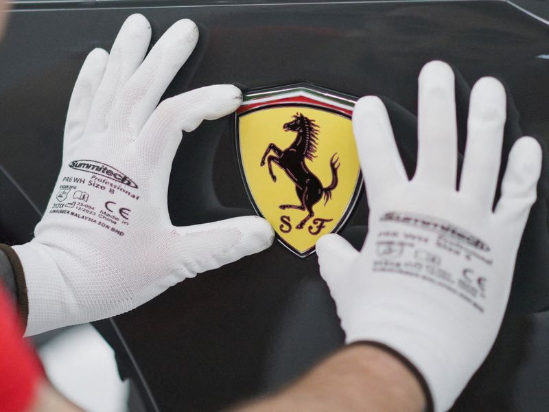 FILE PHOTO: A Ferrari logo is being installed on a Ferrari car at Ferrari's new 'e-building' facility where the luxury sportscar maker is testing lines before an expected start of car production in early 2025, in Maranello, Italy, June 21, 2024. REUTERS/Daniele Mascolo/File Photo