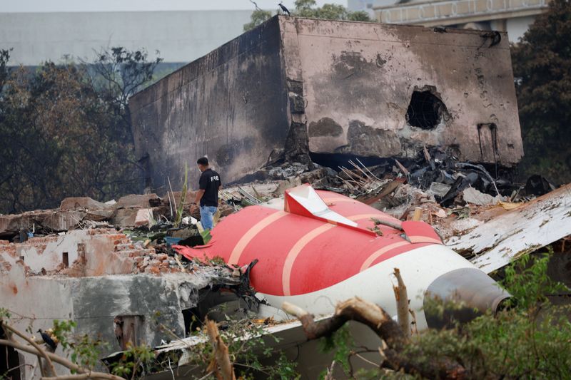 FILE PHOTO: A fire offical stands next to the crashed Air India Boeing 787-8 Dreamliner aircraft, in Ahmedabad, India, June 13, 2025. REUTERS/Adnan Abidi/File Photo