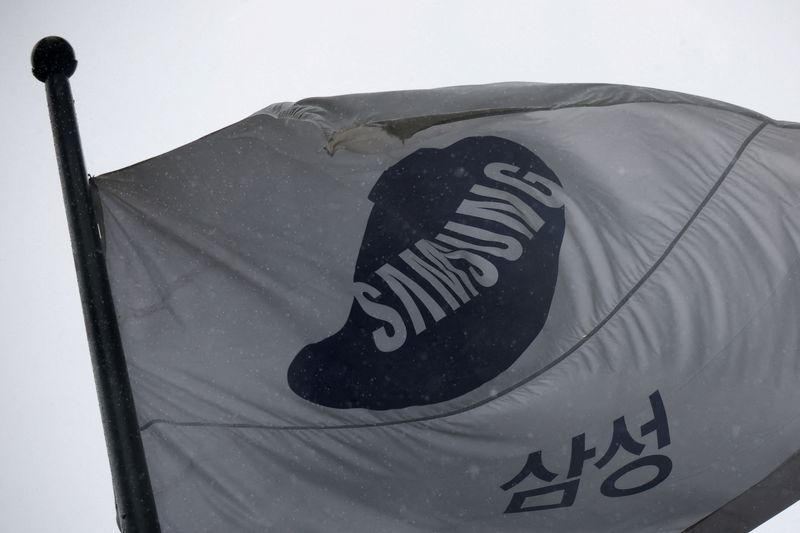 FILE PHOTO: A flag bearing the logo of Samsung Electronics flutters as it rains in front of their office building in Seoul, South Korea, May 20, 2026.   REUTERS/Kim Hong-Ji/File Photo