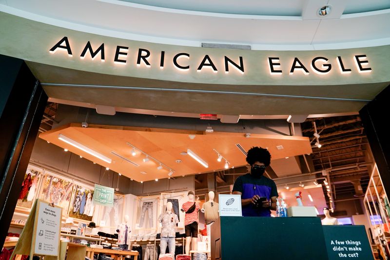An American Eagle Outfitters employee waits for customers at a cleaning station outside a store in Arlington, Virginia, U.S., June 1, 2021. REUTERS/Erin Scott