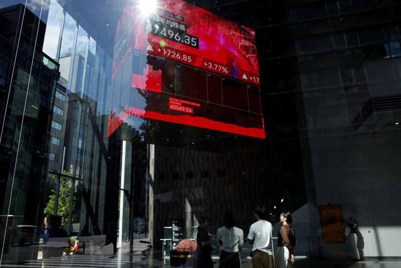 People watch a screen displaying Japan's Nikkei share average in Tokyo, Japan, October 6, 2025. REUTERS/Androniki Christodoulou