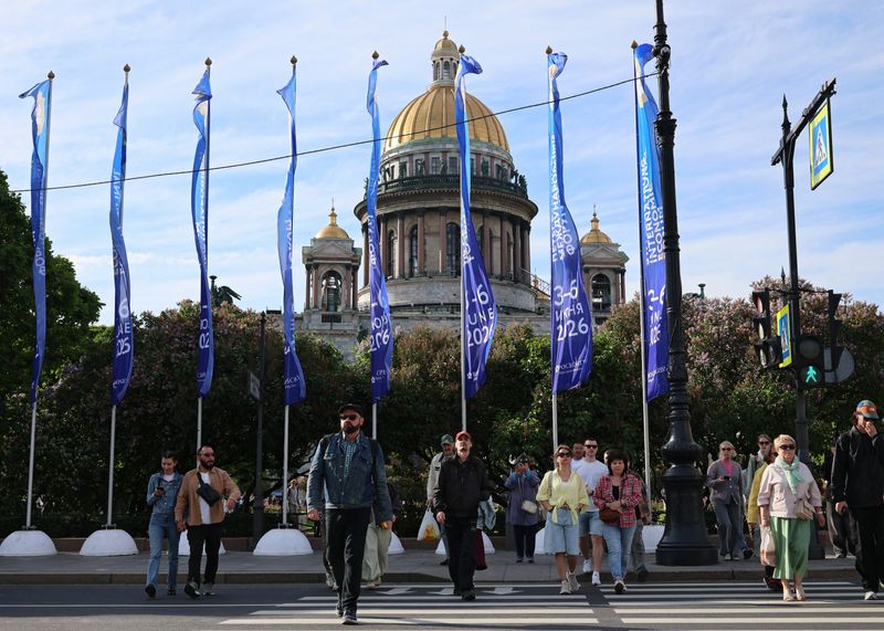 People cross the street near flags with the logo of the St. Petersburg International Economic Forum (SPIEF) flying in front of the St. Isaac's Cathedral on the eve of the forum's opening in Saint Petersburg, Russia June 2, 2026. REUTERS/Anastasia Barashkova