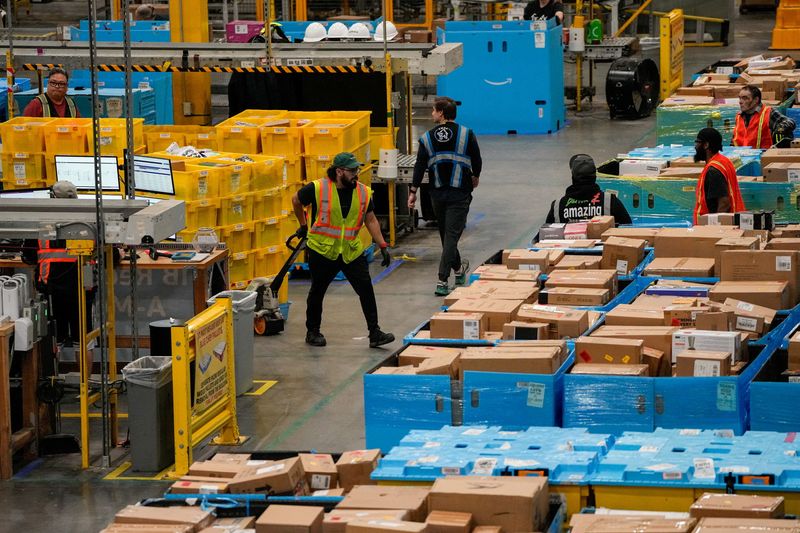 Workers move products during Cyber Monday at Amazon's fulfilment center in Robbinsville, New Jersey, U.S., December 1, 2025. REUTERS/Eduardo Munoz