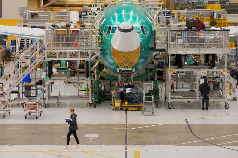 A Boeing worker passes by a 737 MAX airplane on the final assembly production line during a media tour of the Boeing factory in Renton, Washington, U.S., April 15, 2026.   REUTERS/Genna Martin