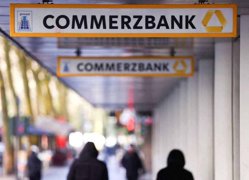 FILE PHOTO: People walk past logos of Commerzbank at a branch, in Cologne, Germany, March 16, 2026. REUTERS/Thilo Schmuelgen/File Photo