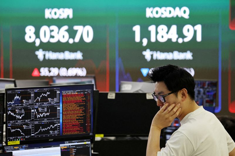 FILE PHOTO:  A currency dealer works as an electronic board displays the Korea Composite Stock Price Index (KOSPI) and the Korea Securities Dealers Automated Quotations (KOSDAQ), at the dealing room of a bank in Seoul, South Korea, May 15, 2026.   REUTERS/Kim Hong-Ji/File Photo
