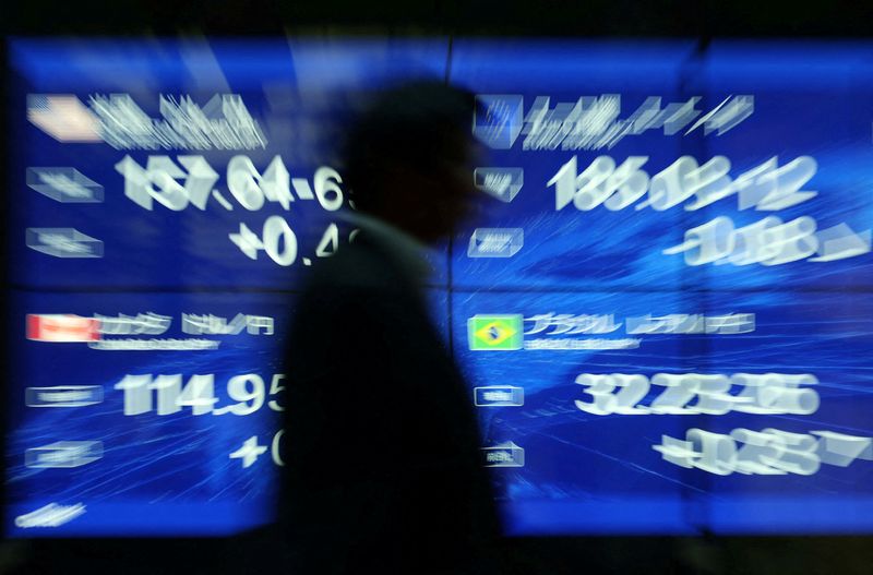 FILE PHOTO: A passersby walks past an electronic screen displaying the current Japanese Yen exchange rate against the U.S. dollar, Euro and other foreign currencies in Tokyo, Japan May 12, 2026. REUTERS/Issei Kato/File Photo