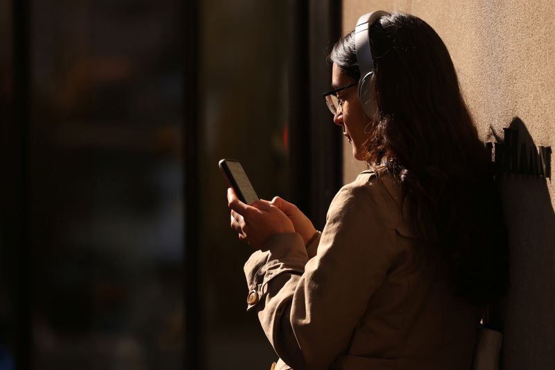 FILE PHOTO: A person uses a smartphone in Manhattan, New York City, U.S., February 11, 2022. REUTERS/Andrew Kelly/File Photo