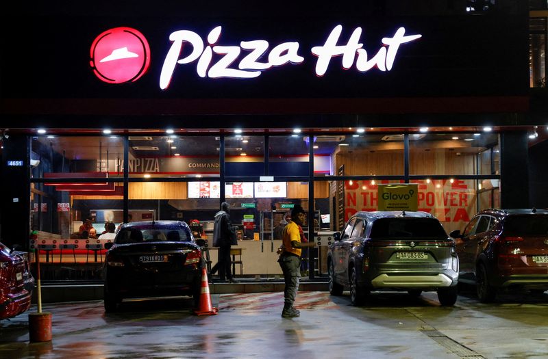 FILE PHOTO: A security guard stands in front of a Pizza Hut fast food restaurant in Abidjan, Ivory Coast October 5, 2024. REUTERS/Luc Gnago/File Photo