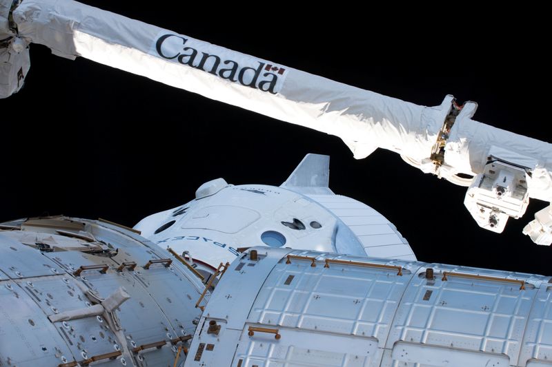 The Canadarm2 robotic arm, built by Canadian technology company MDA, is seen over the uncrewed SpaceX Crew Dragon spacecraft as it makes the first Commercial Crew vehicle to visit the International Space Station March 4, 2019. Picture taken March 4, 2019.   NASA/Handout via REUTERS.