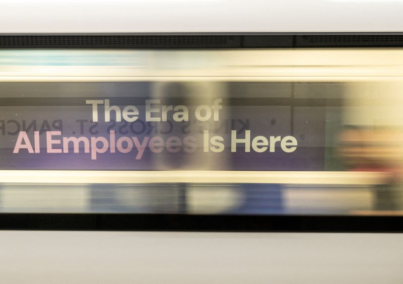 FILE PHOTO: A London underground train passes a billboard for an Artificial Intelligence company advertising AI employees in London, Britain, June 5, 2025. REUTERS/Chris J. Ratcliffe/File Photo