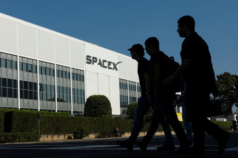SpaceX employees cross the road as they go to work at the SpaceX facility in Hawthorne on the day of their company's IPO, in Hawthorne, California, U.S. June 12, 2026.  REUTERS/Mike Blake