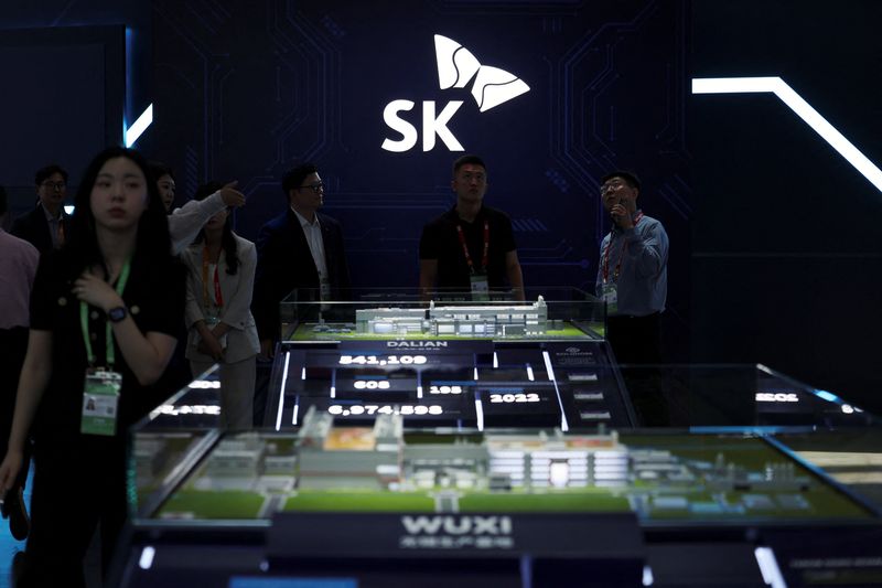 People stand near a logo of SK Hynix at the South Korean chipmaker's booth during the China International Supply Chain Expo (CISCE) in Beijing, China June 22, 2026. REUTERS/Florence Lo