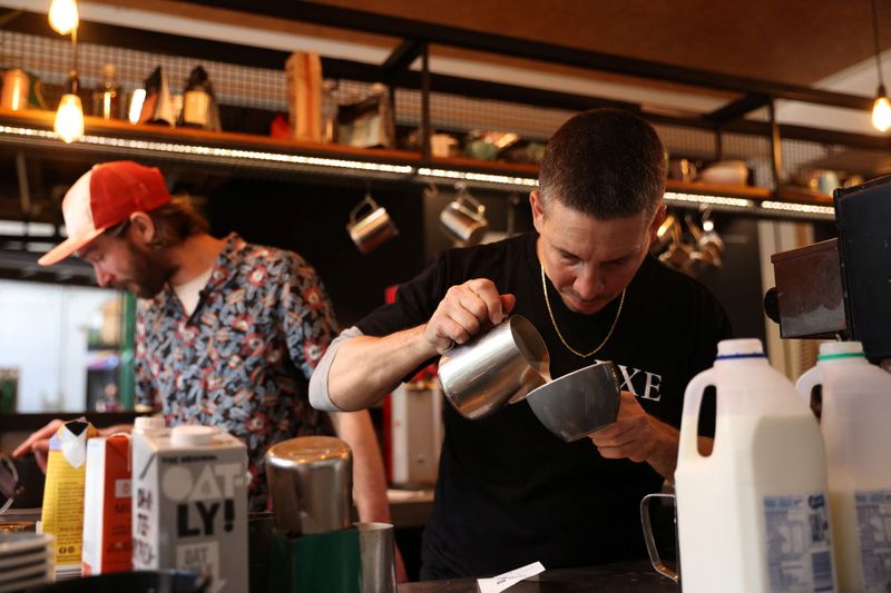 Barista Claudio Chimisso prepares a coffee at Bay Ten Espresso, a cafe that has struggled with filling staff job openings in recent months due to a worker shortage according to its owner, in Sydney, Australia, August 31, 2022. REUTERS/Loren Elliott