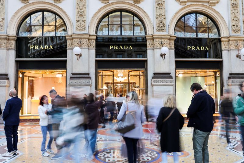 People walk past a Prada store in Galleria Vittorio Emanuele II, in Milan, Italy, September 27, 2025. REUTERS/Yara Nardi