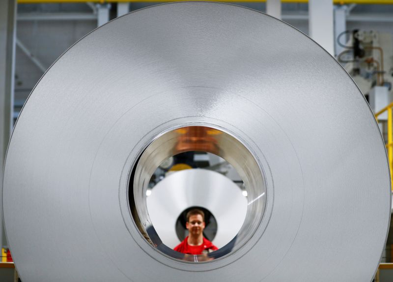 FILE PHOTO: A worker poses for a photo through an aluminium coil during opening of a production line for the car industry at a branch of Norway's Hydro aluminum company in Grevenbroich, Germany May 4, 2017.    REUTERS/Wolfgang Rattay/File Photo