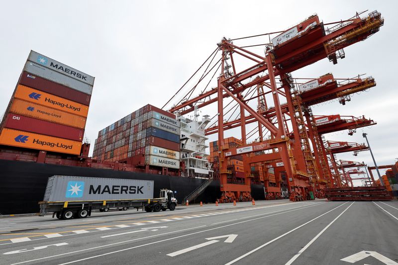 A truck carries a container near a cargo ship at the Port of Vancouver in Vancouver, British Columbia, Canada August 3, 2025.  REUTERS/Chris Helgren