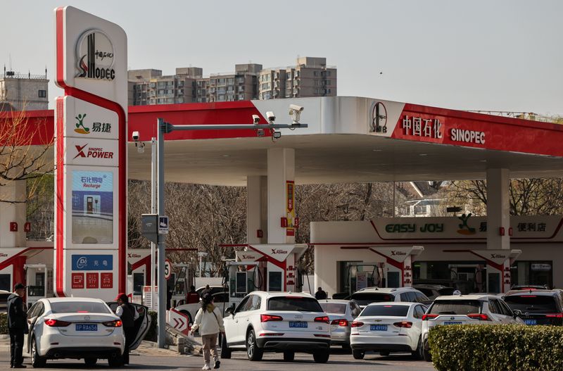 FILE PHOTO: Cars queue at a Sinopec petrol station ahead of an announced fuel price hike, amid the U.S.–Israeli conflict with Iran, in Beijing, China, March 22, 2026. REUTERS/Maxim Shemetov/File Photo